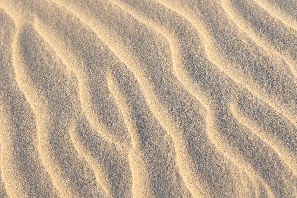 a sand dune with wavy lines in the sand