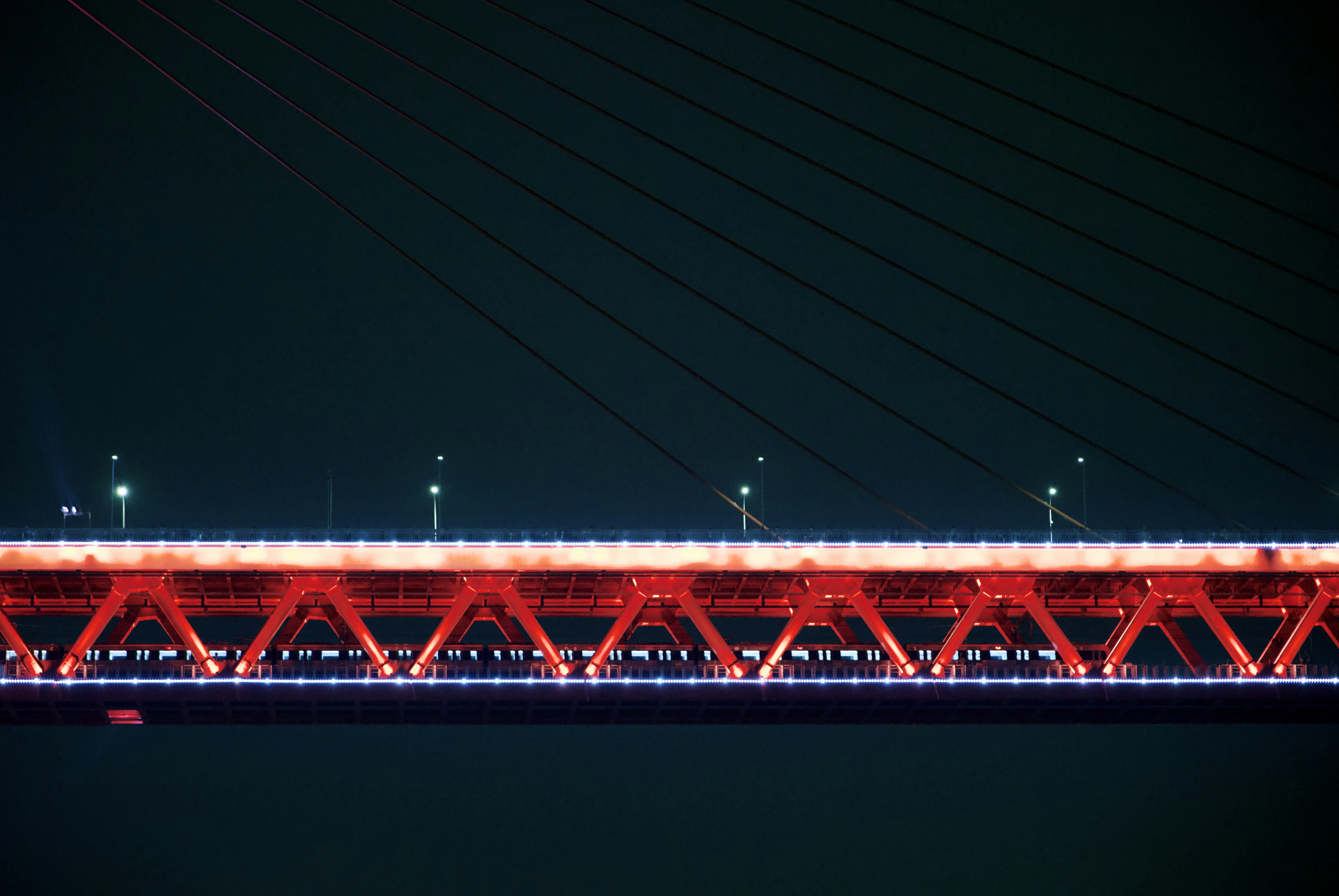 a red and white bridge lit up at night