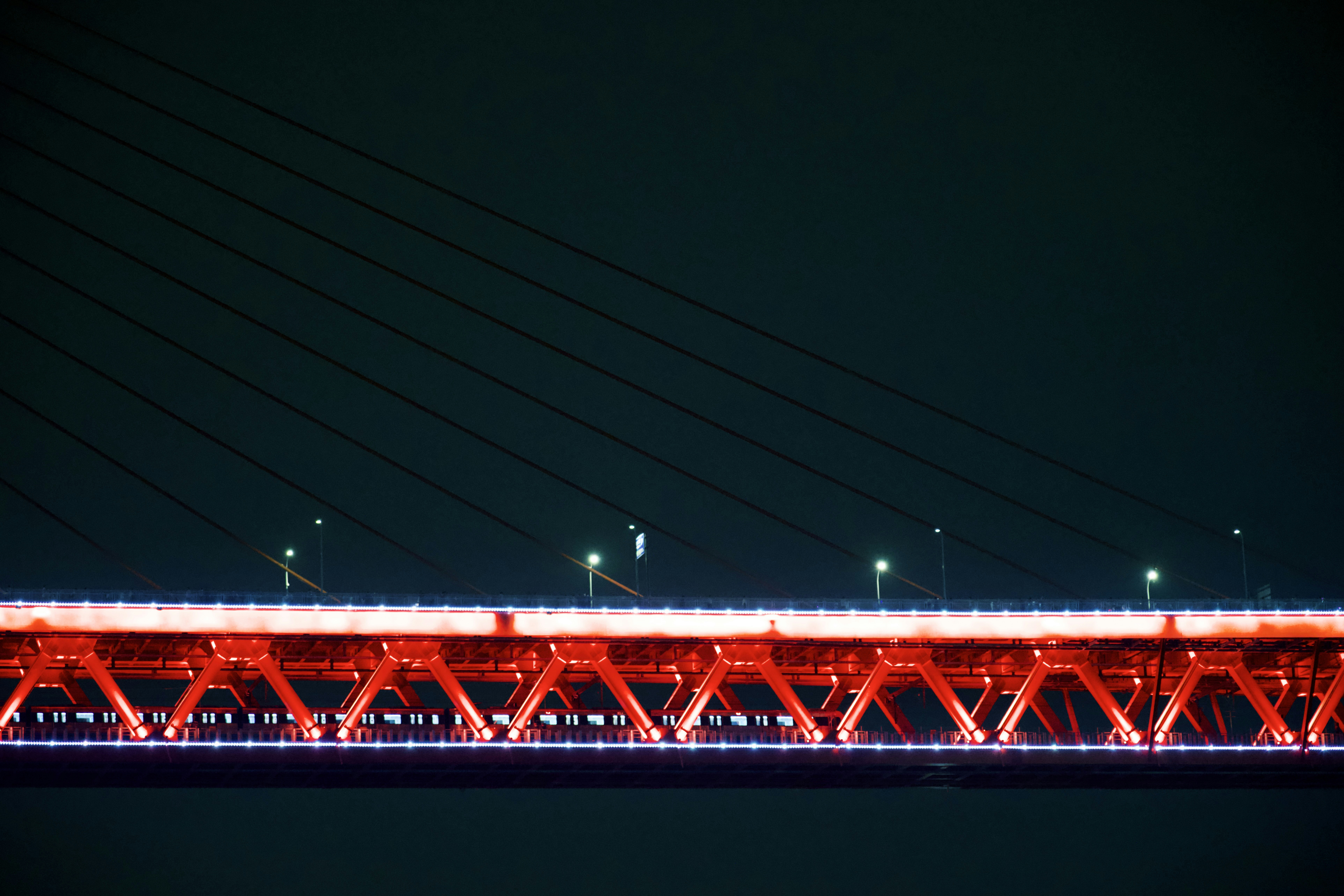a long red bridge lit up at night