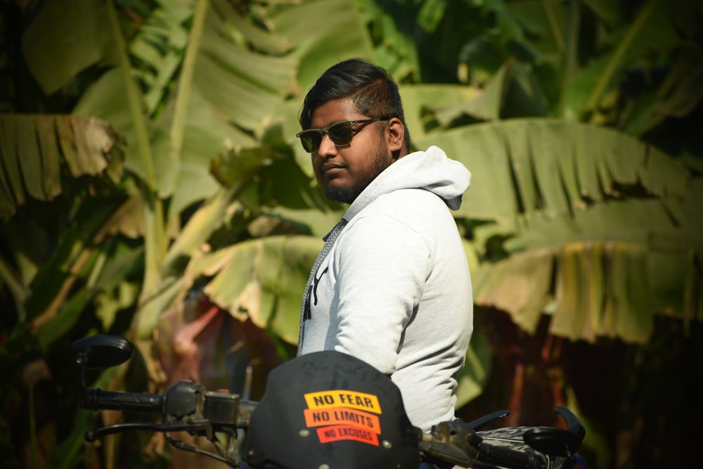 a man in a hoodie is sitting on a motorcycle