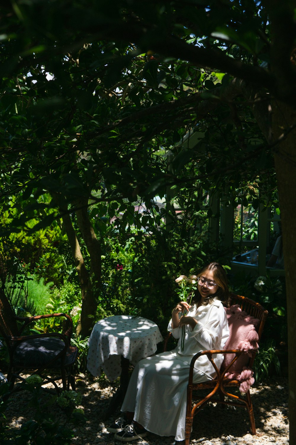 a woman sitting at a table in a garden
