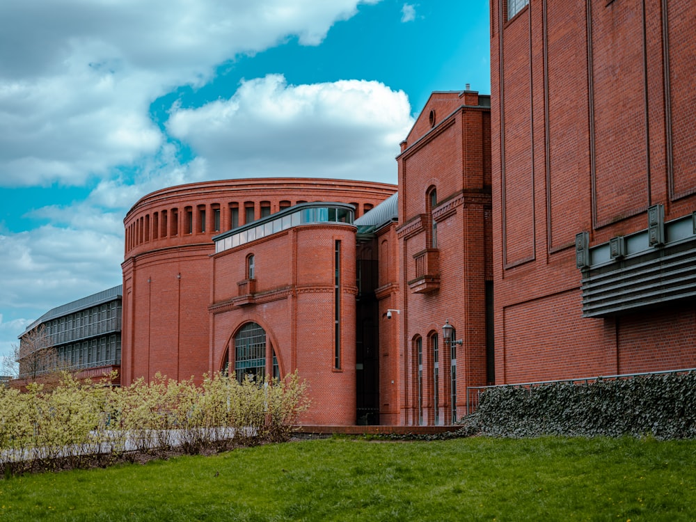 a red brick building with a green lawn in front of it