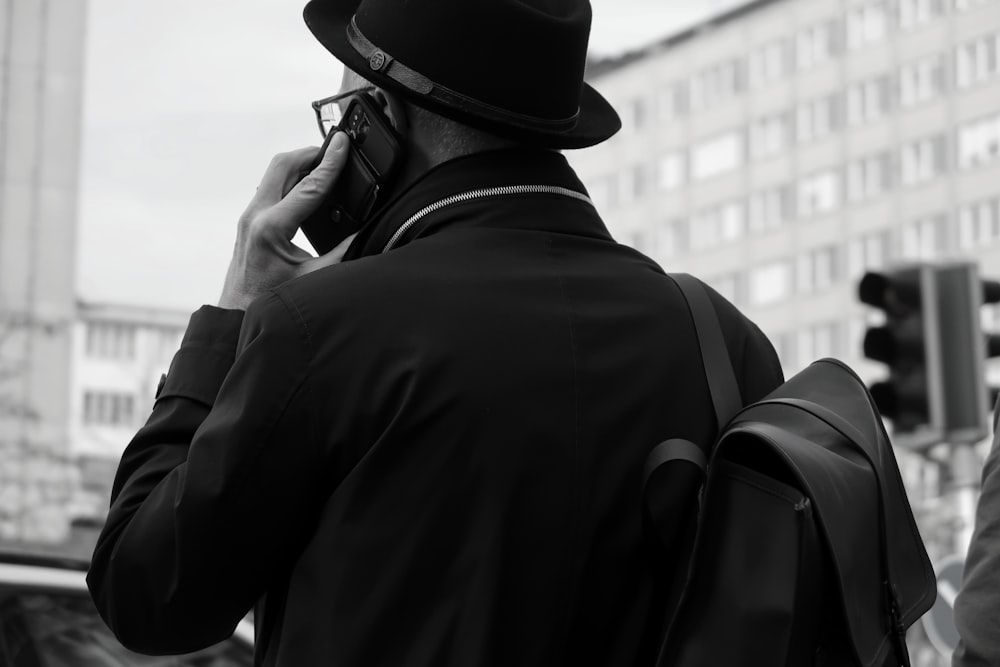 Un hombre con sombrero y mochila hablando por celular