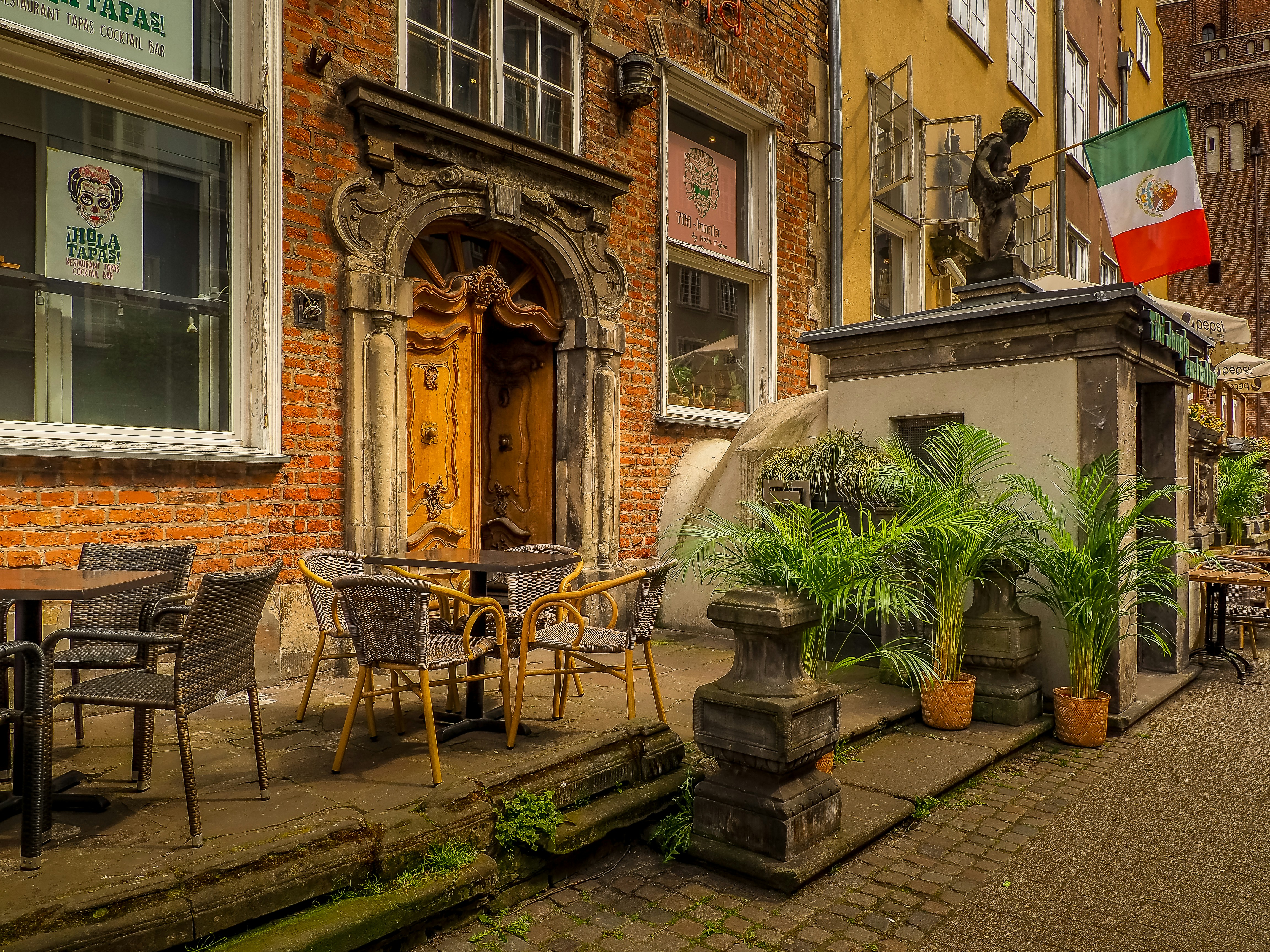 a courtyard with tables and chairs and a statue