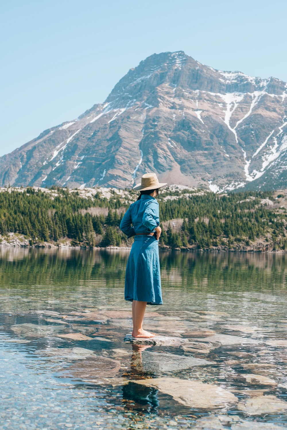 a woman standing on a rock in the water