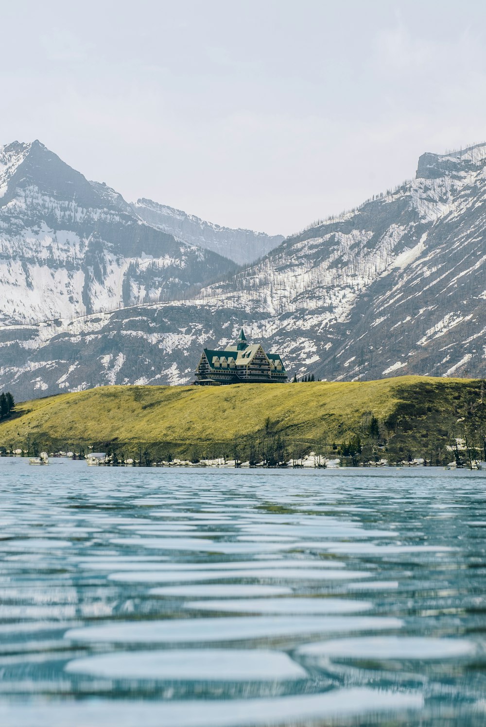 a house sitting on top of a hill next to a body of water