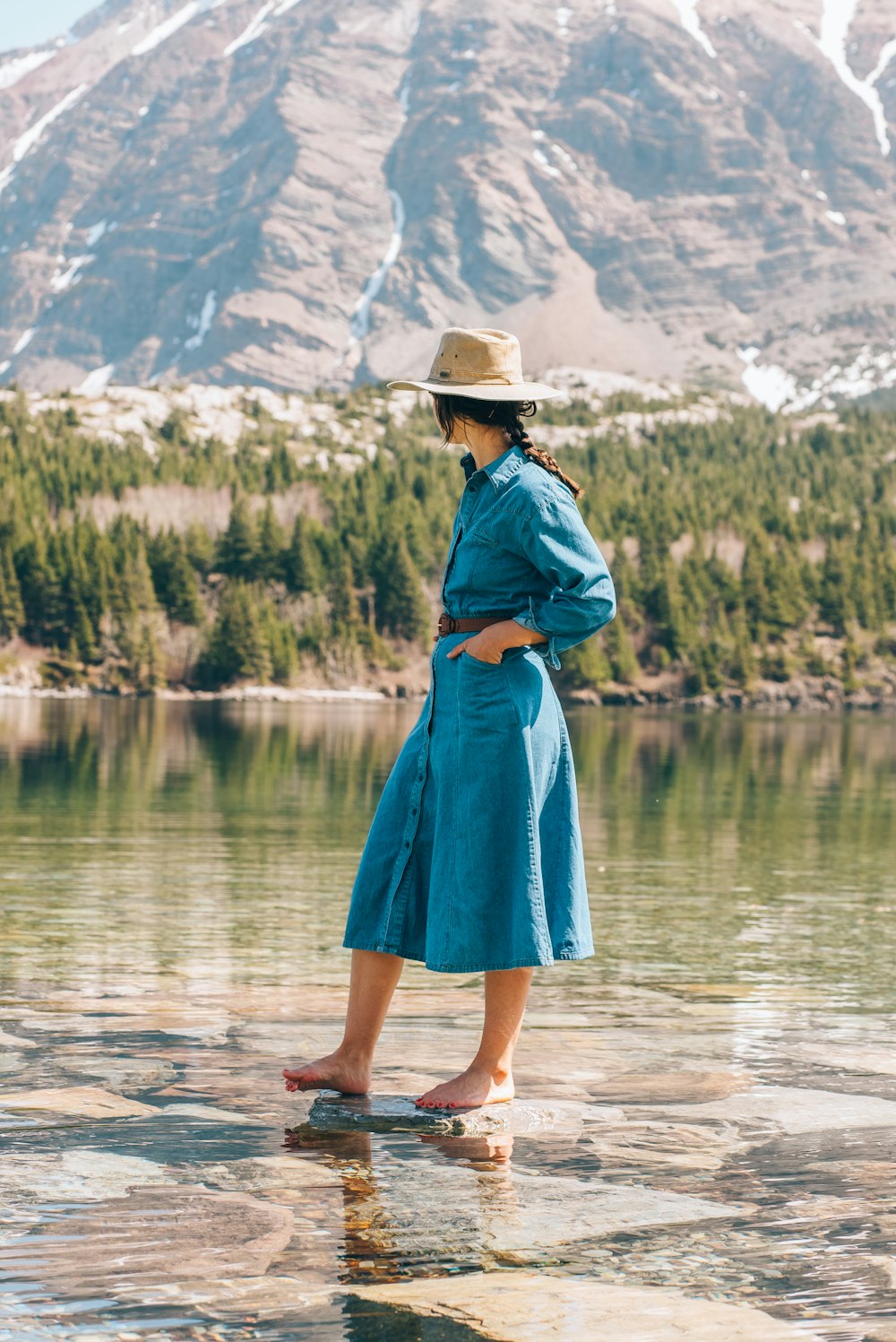 a woman standing on a rock in front of a mountain