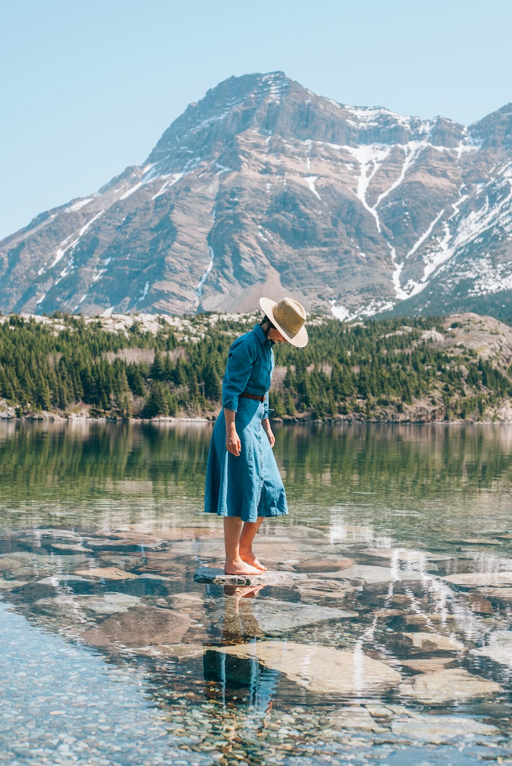 a woman standing on a rock in the water