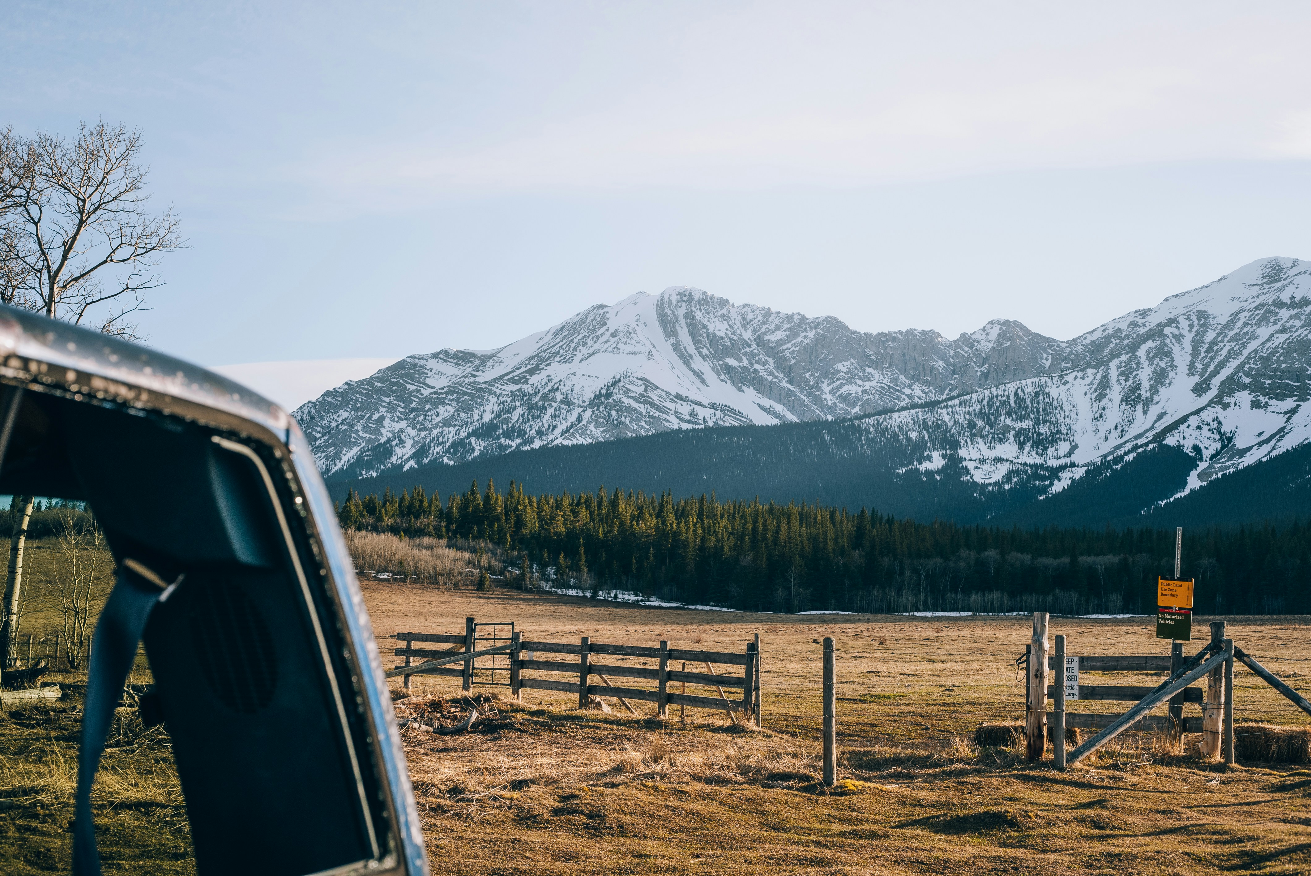 a car parked in a field with mountains in the background
