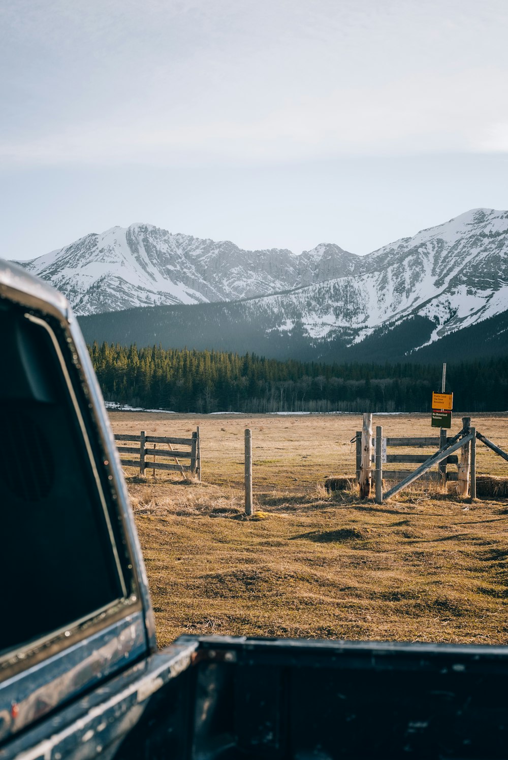 a truck parked in a field with mountains in the background
