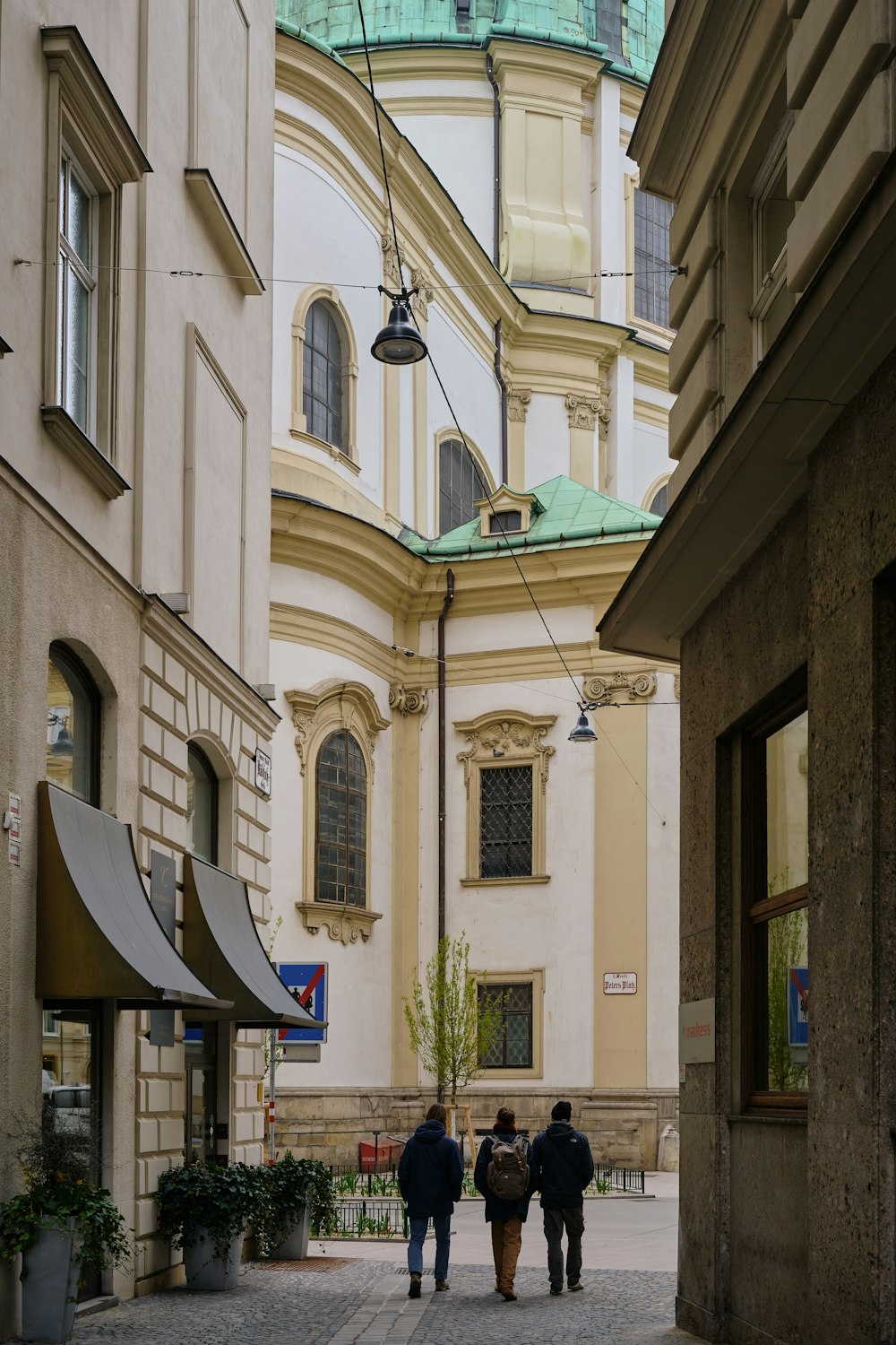 a couple of people walking down a street next to tall buildings