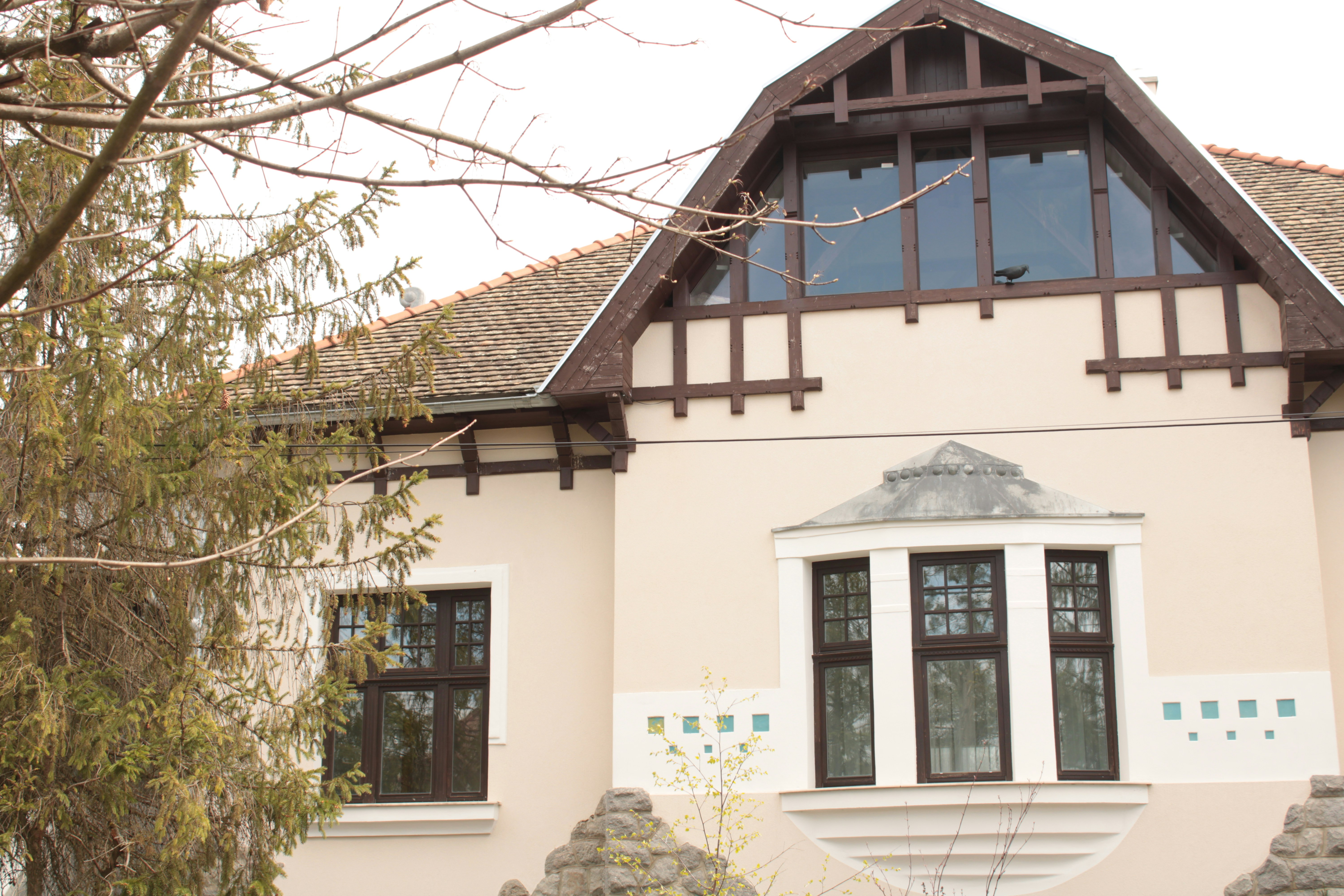 Una casa blanca con techo y ventanas marrones