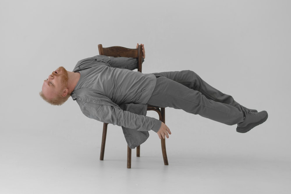 a man laying on a chair in the middle of the floor