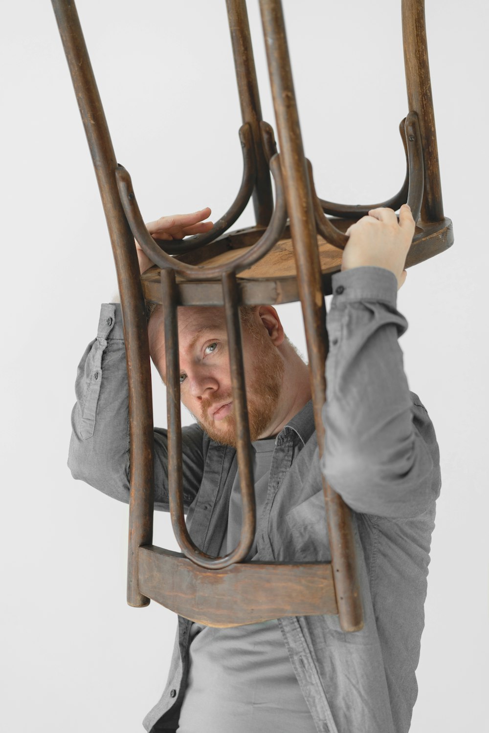 a man is holding up a wooden sculpture