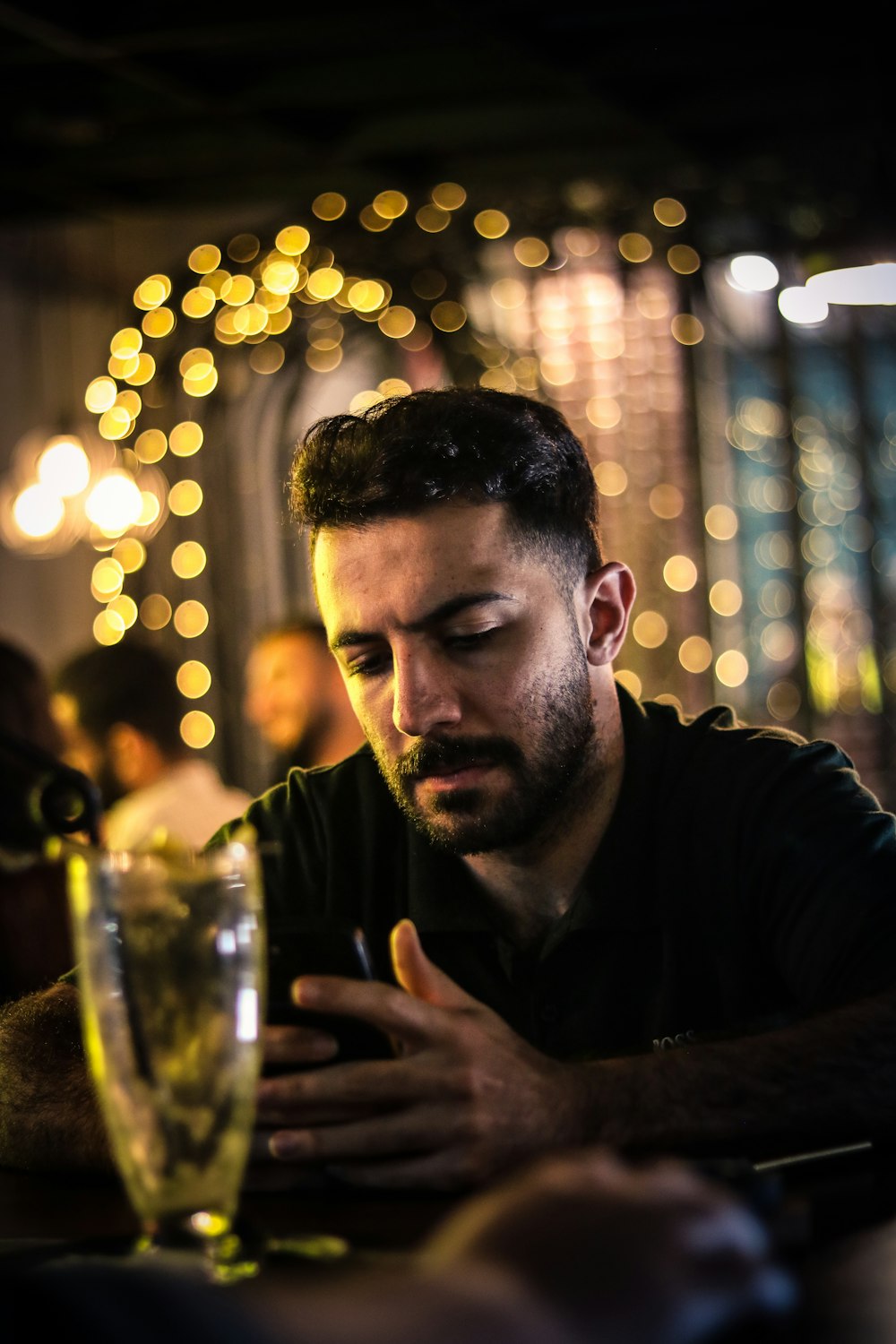 a man sitting at a table looking at his cell phone