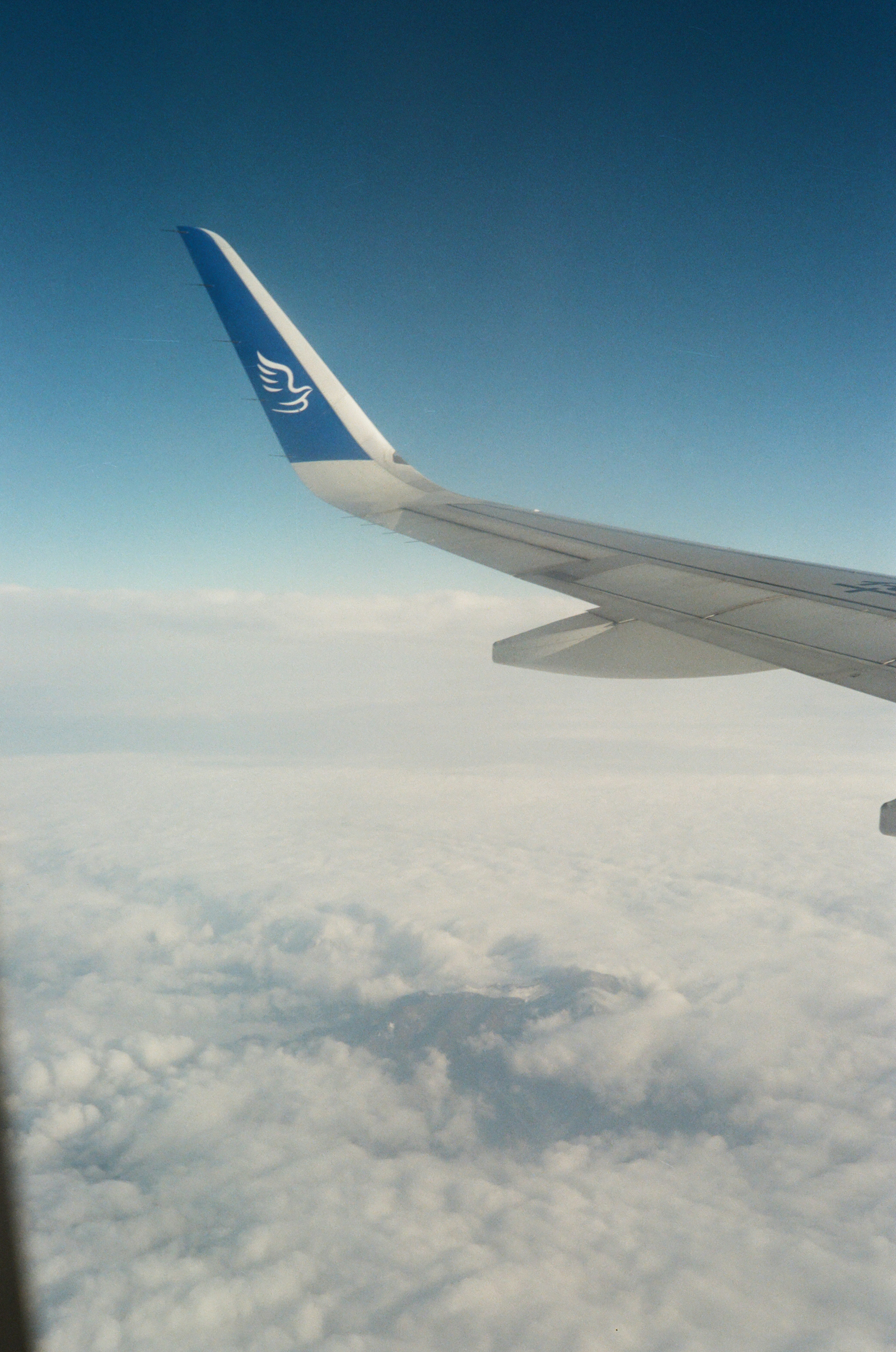 the wing of an airplane flying above the clouds