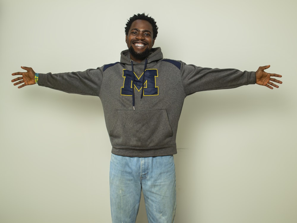 a man standing with his arms outstretched in front of a wall