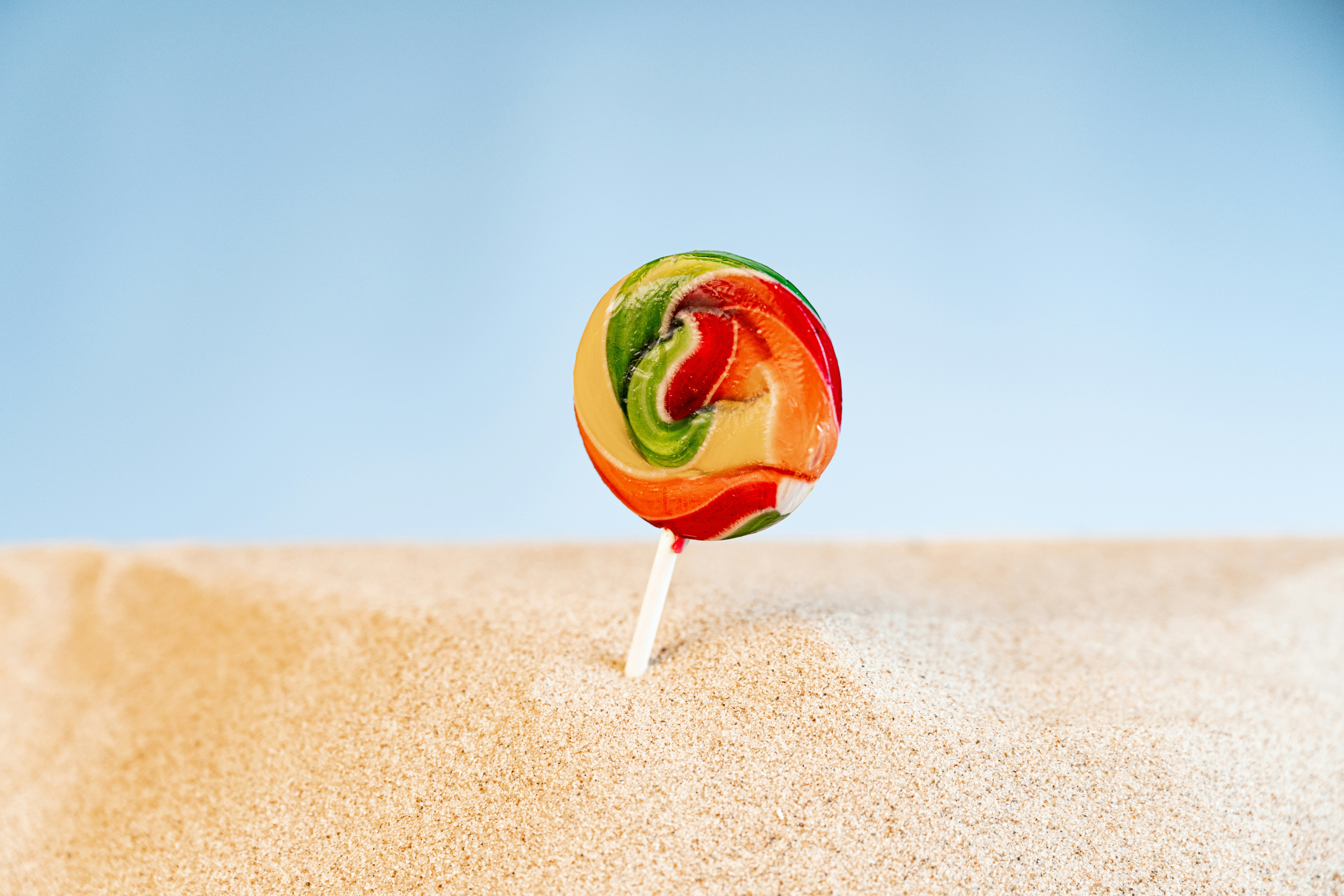 a lollipop sitting on top of a sandy beach