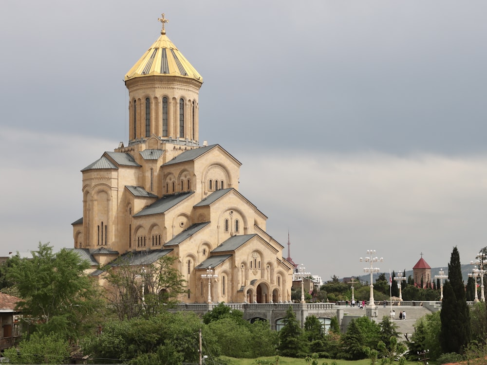 a large church with a golden dome on a cloudy day