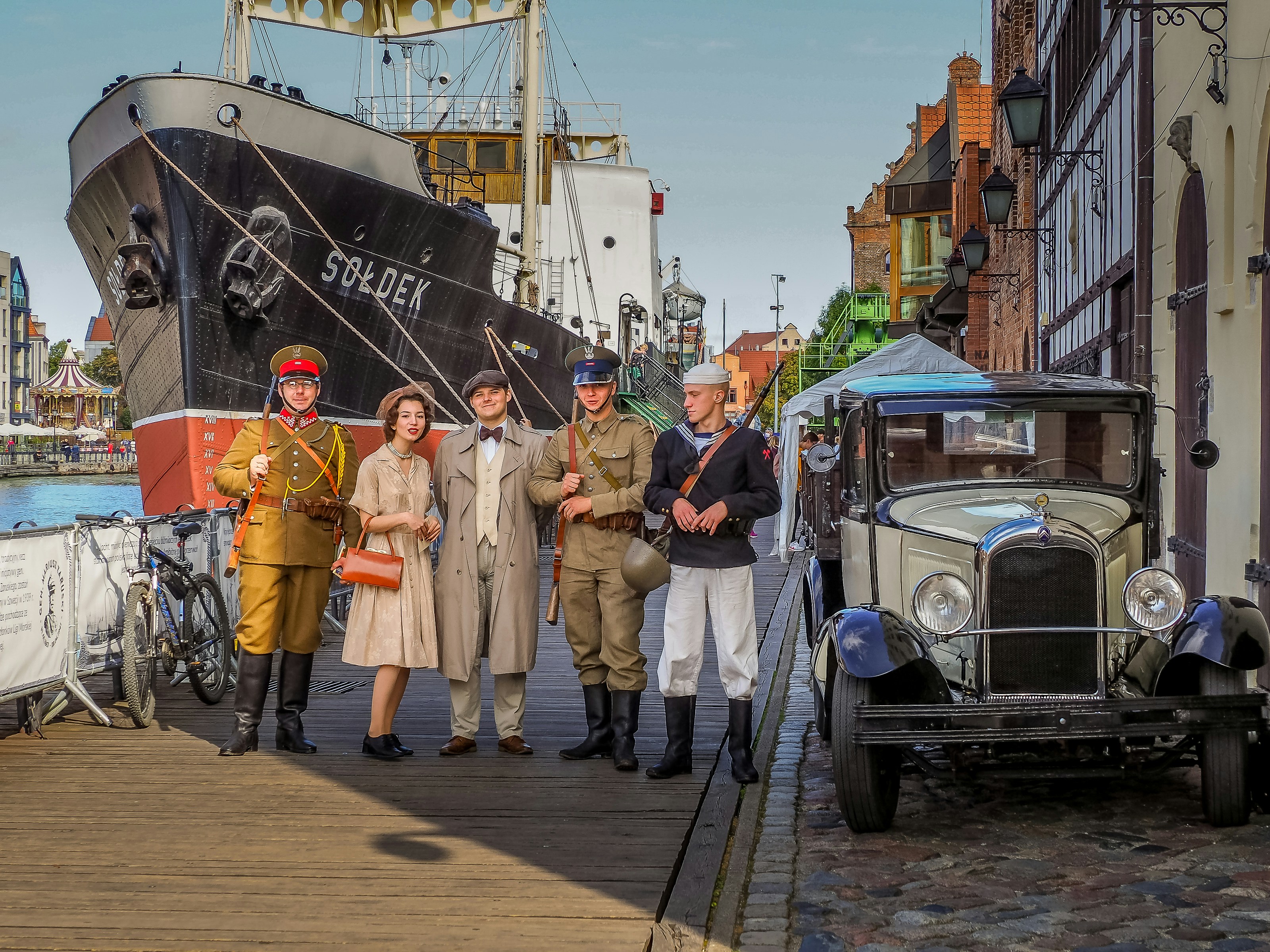 a group of people standing on a dock next to a boat