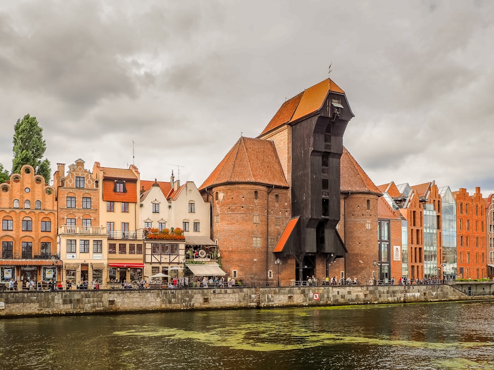 a building with a clock on the side of it next to a body of water