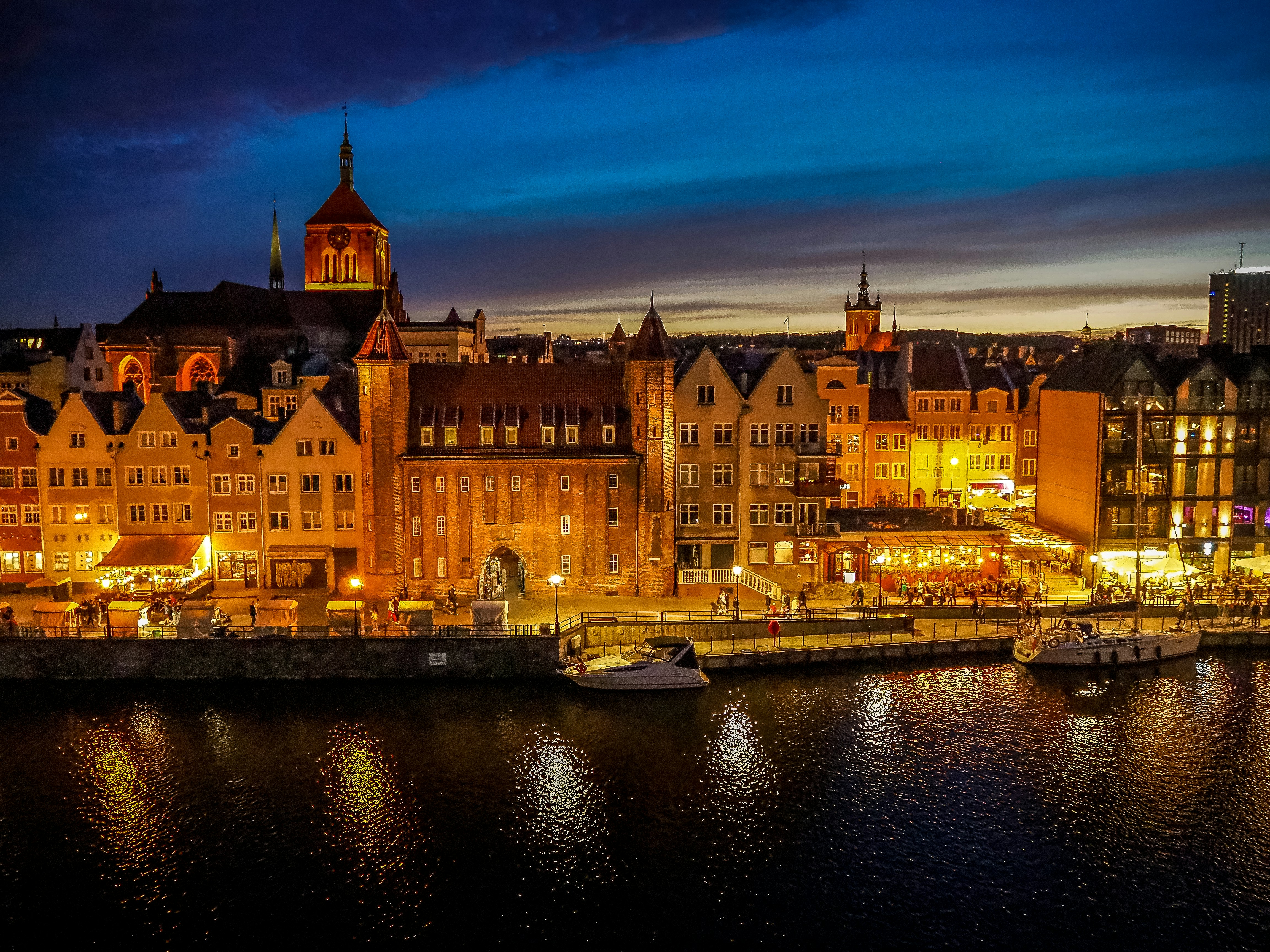 a night view of a city with boats in the water, 