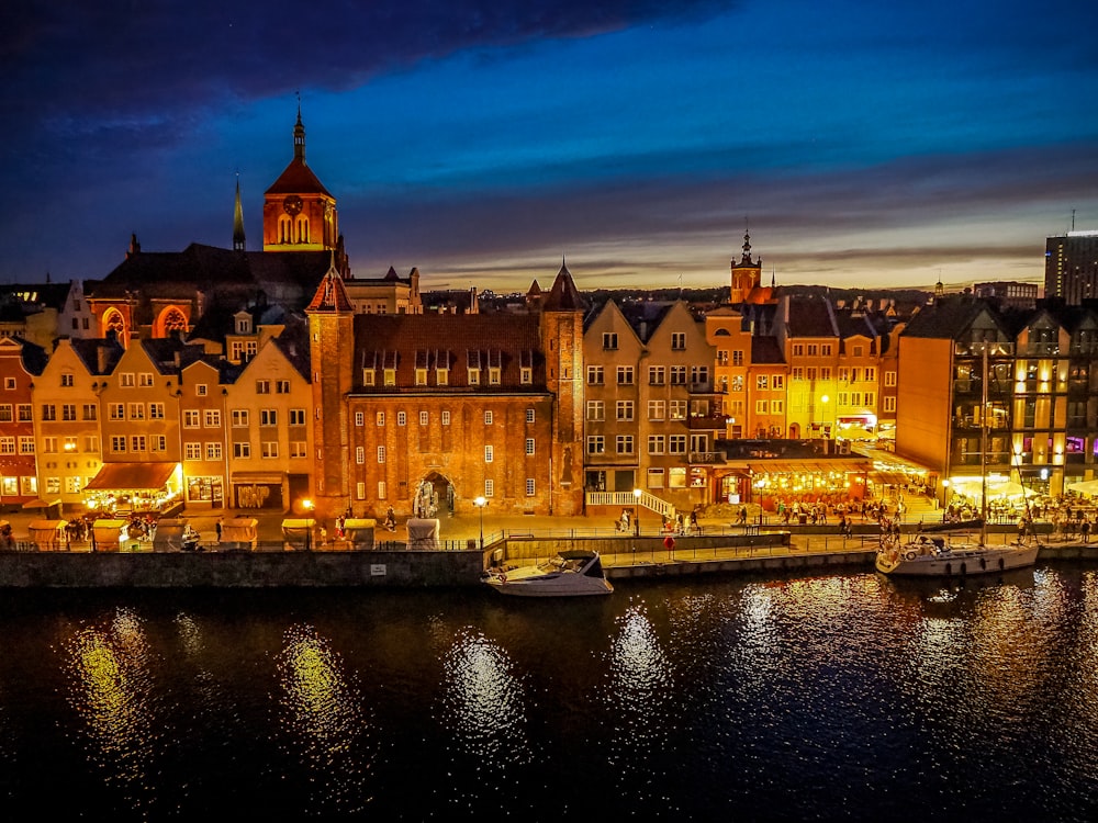 a night view of a city with boats in the water