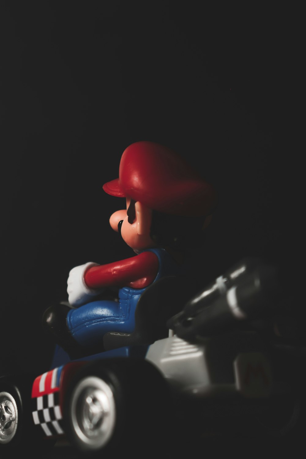 a toy car with a mario kart figure sitting on top of it