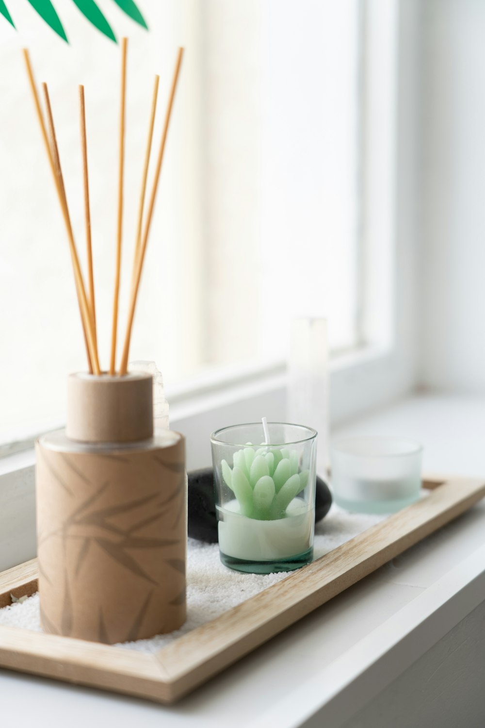 a tray with a plant and a candle on it