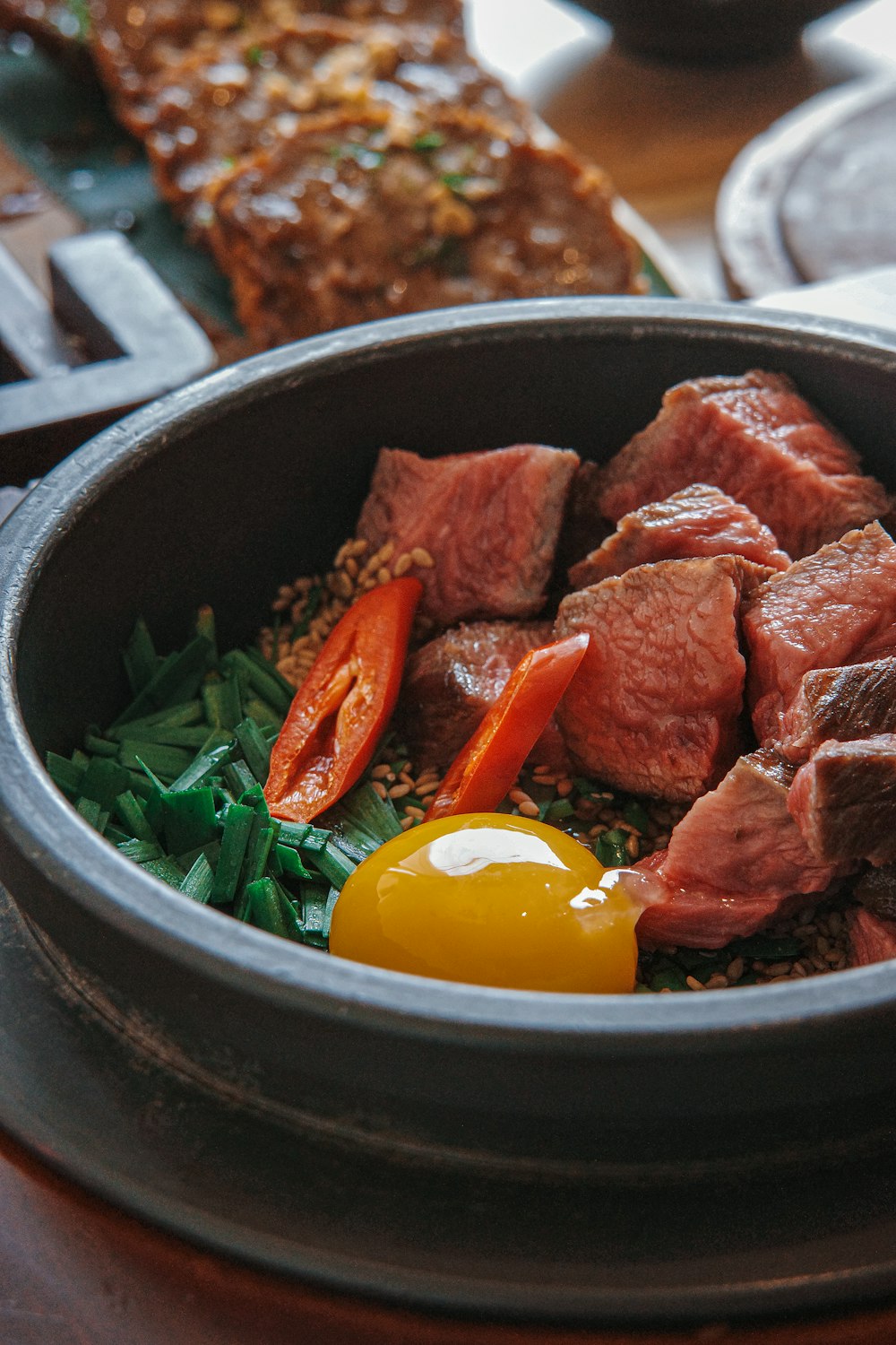 a bowl filled with meat and vegetables on top of a table