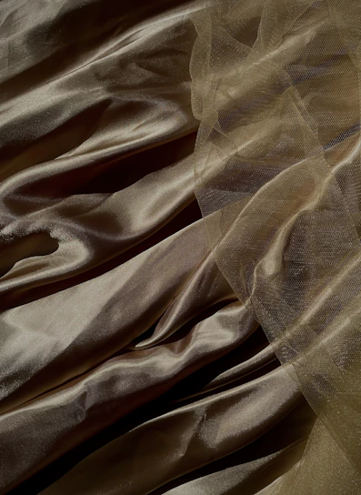 Gleaming silk fabric sparkling under warm light, draped elegantly