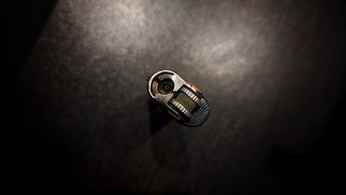 A subtle close-up of a matte gold keyhole on a deep black velvet background.