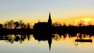 A peaceful moment of reflection with a sunset backdrop behind the church building.