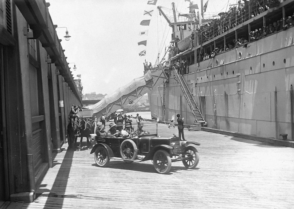 a vintage photo of an old car on a dock