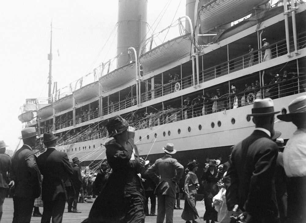 a black and white photo of people on a dock