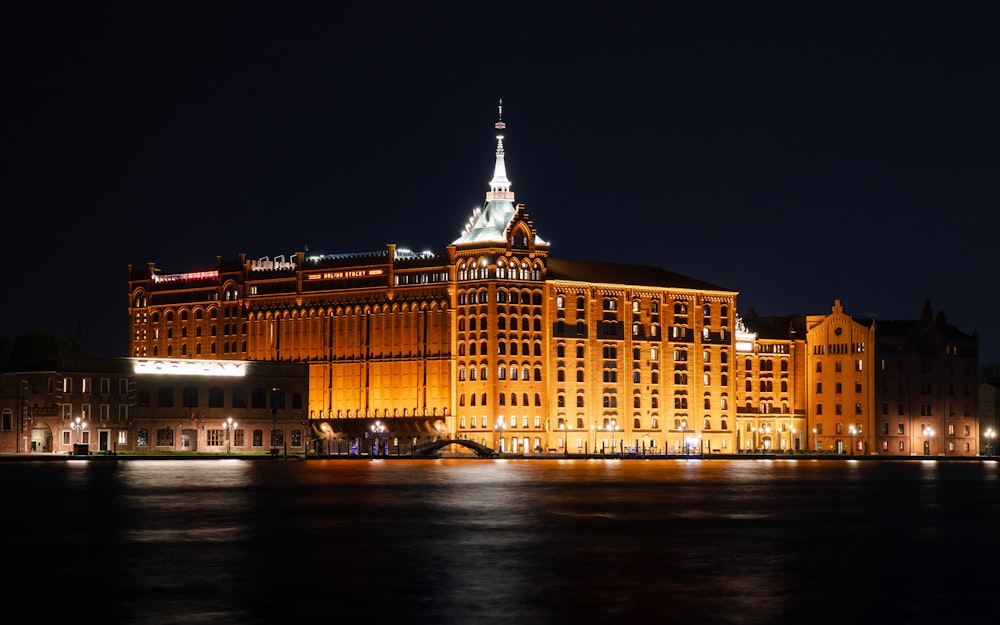 a large building lit up at night on the water
