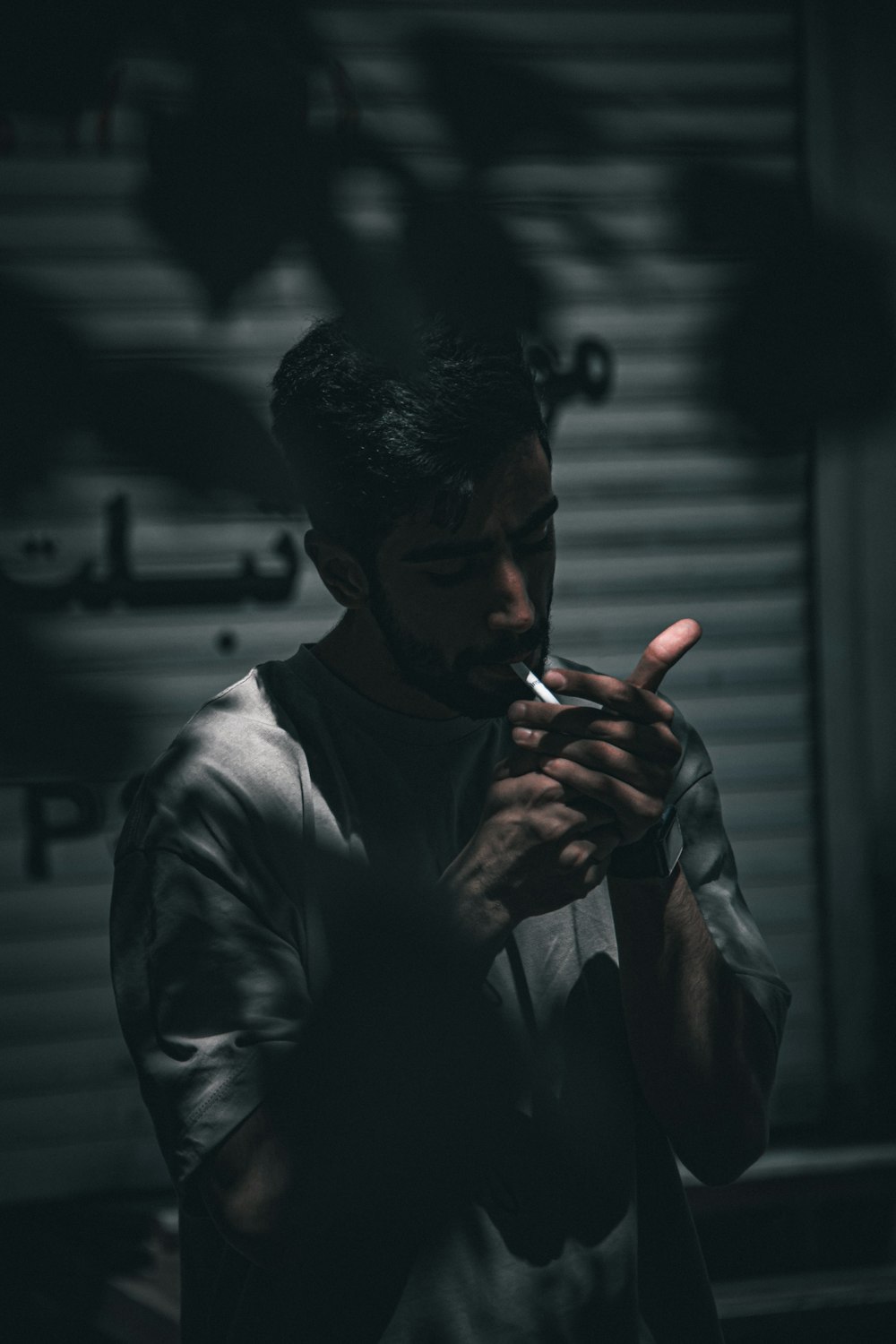 a man smoking a cigarette in a dark room