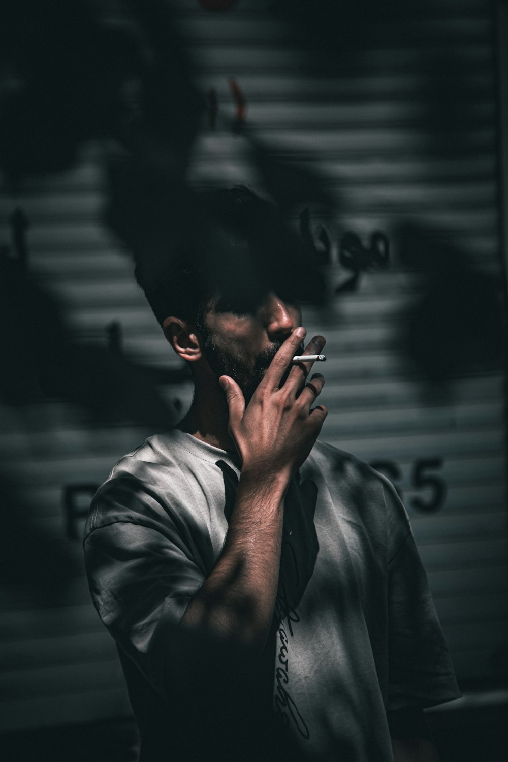 a man smoking a cigarette in a dark room