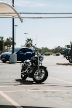 Motorcycle being carefully loaded onto a tow truck under a clear blue sky.