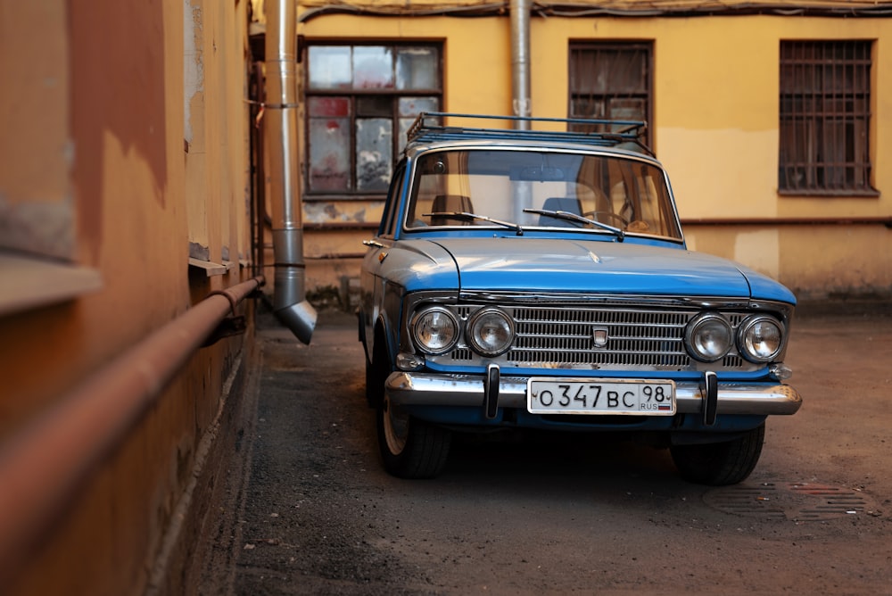 Un coche azul aparcado frente a un edificio amarillo