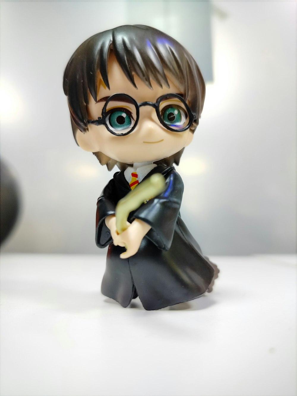 a harry potter figurine holding a wand