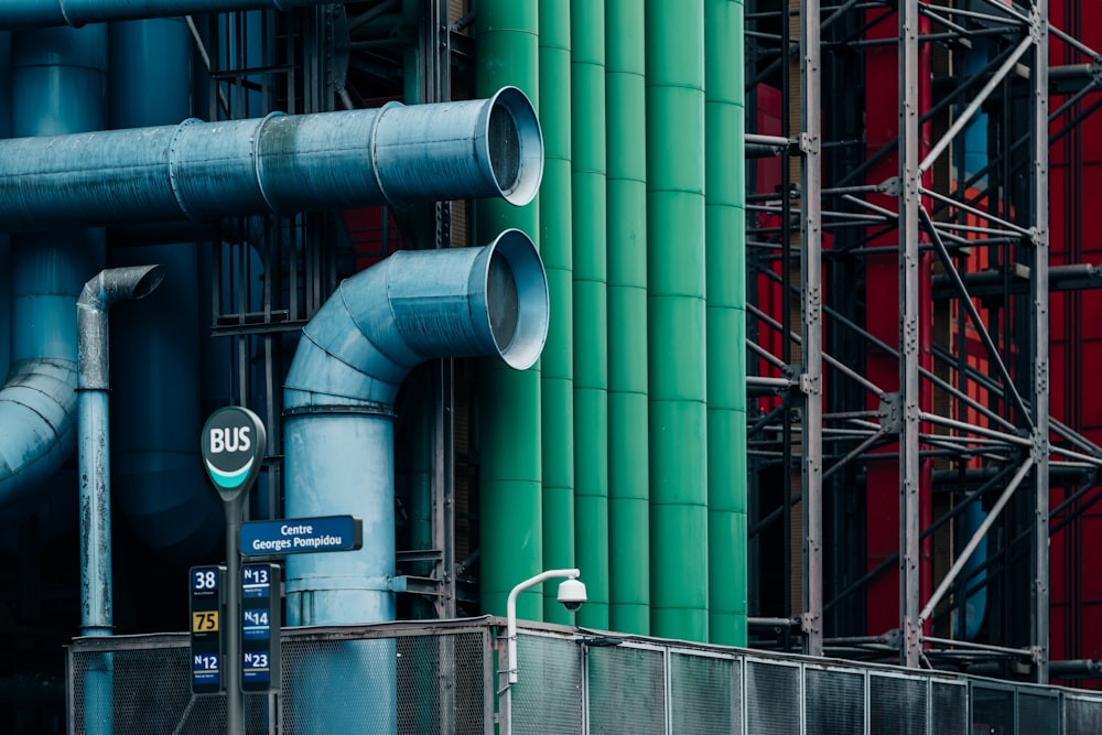 a building with pipes and a street sign