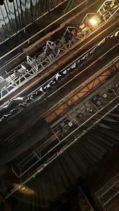 A complex automated rig lifting scenic elements during a live theater performance.