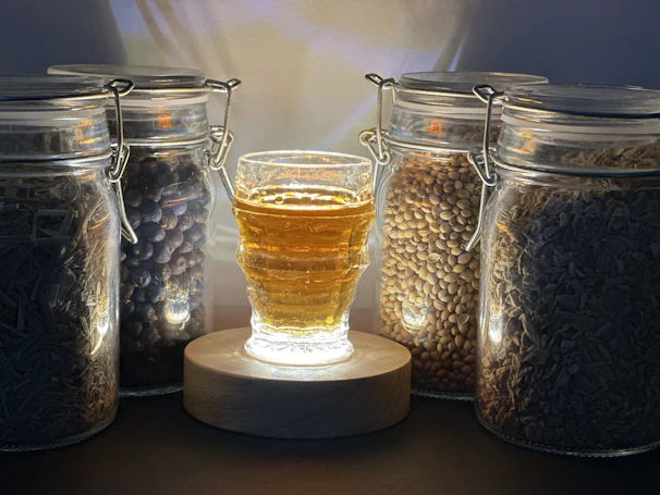 Several small glass vials filled with bright gold flakes, lined up on a rustic table.