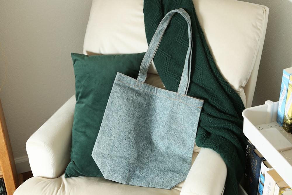 a blue bag sitting on top of a white chair