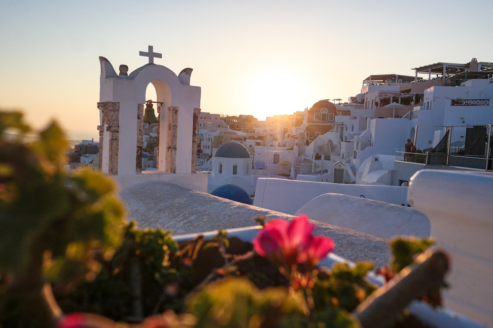 the sun is setting over a city with white buildings