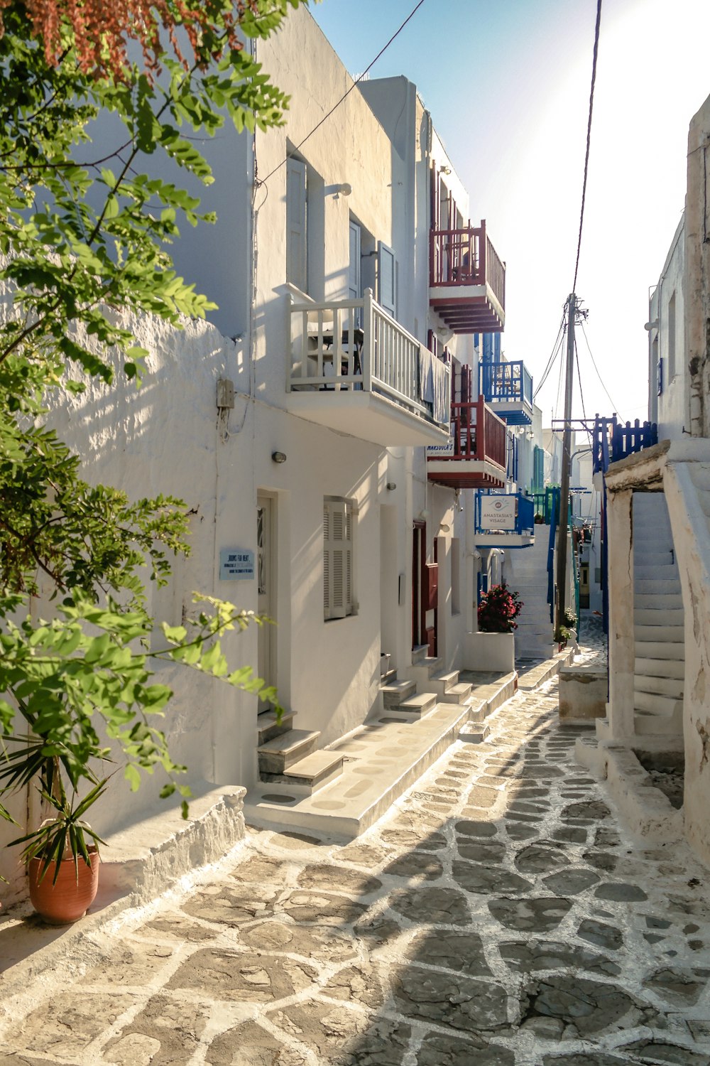 a cobblestone street lined with white buildings