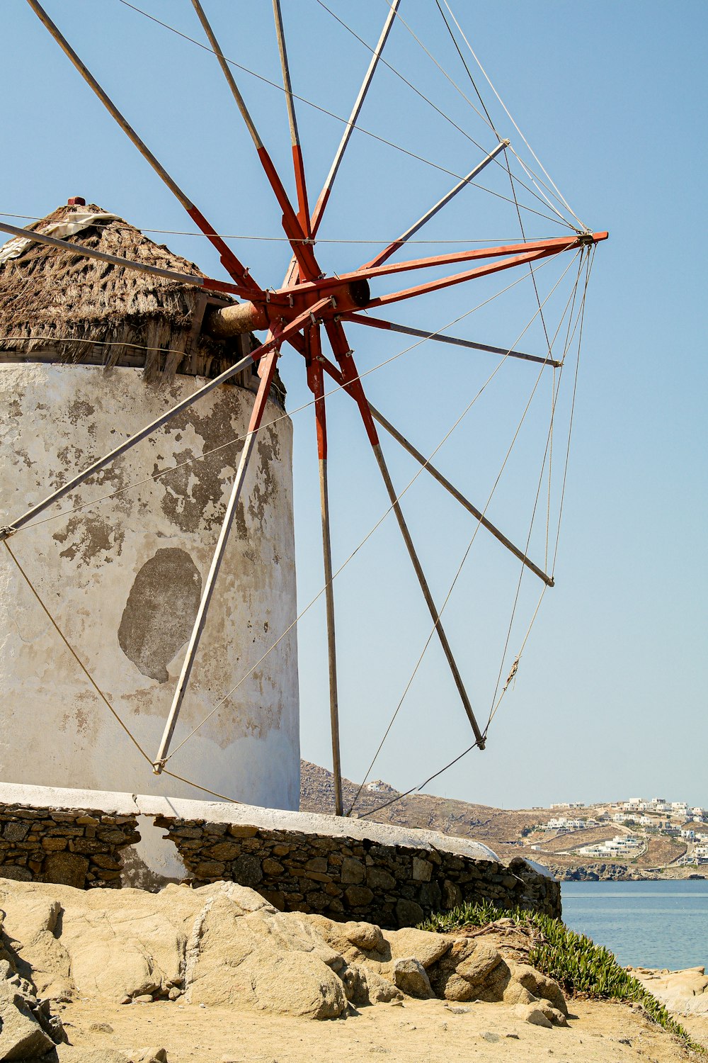 a large white windmill sitting next to a body of water