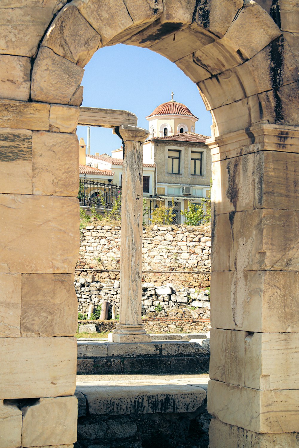 a stone arch with a clock tower in the background