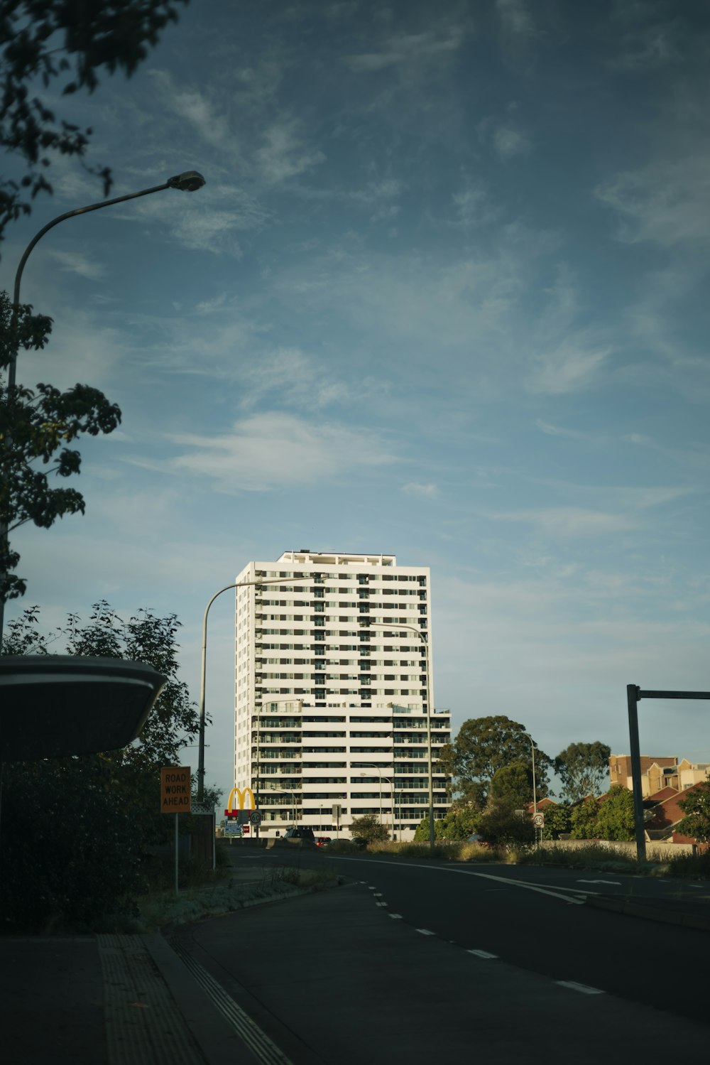 a tall white building sitting on the side of a road